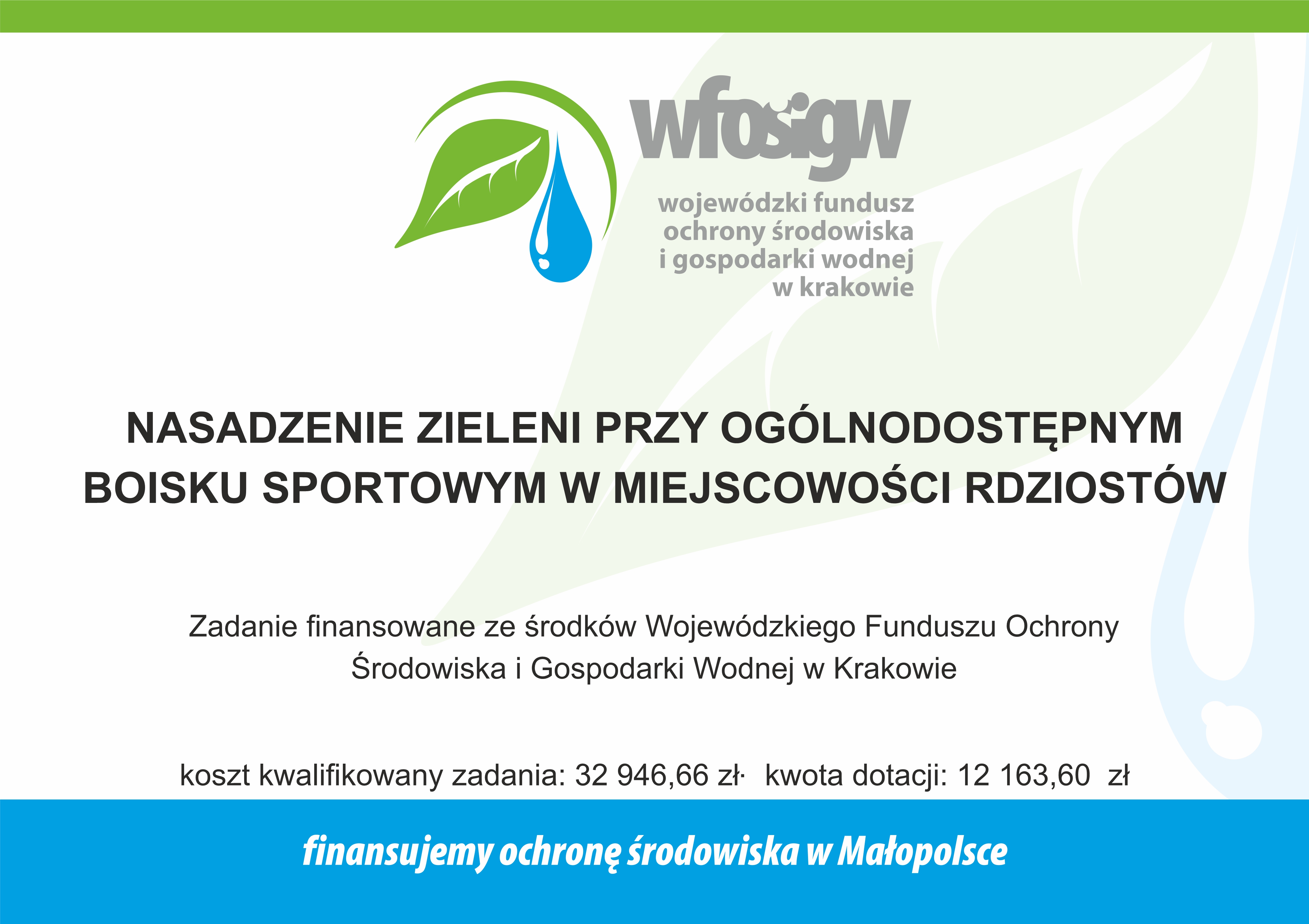 Tablica informacyjna: od góry logo Wójewódzkiego Funduszu Ochrony Środowiska i Gospodarki Wodnej w Krakowie - poniżej tekst -  NASADZENIE ZIELENI PRZY OGÓLNODOSTĘPNYM  BOISKU SPORTOWYM W MIEJSCOWOŚCI RDZIOSTÓW  Zadanie finansowane ze środków Wojewódzkiego Funduszu Ochrony  Środowiska i Gospodarki Wodnej w Krakowie  koszt kwalifikowany zadania: 32 946,66 zb kwota dotacji: 12 163,60 zł  finansujemy ochronę środowiska w Małopolsce  