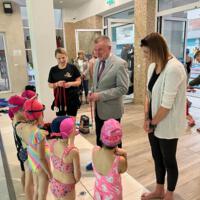 Uczestnicy projektu - dzieci - na basenie - wójt gminy wręcza medale - dzieci w strojach kąpielowych - wójt w garniturze