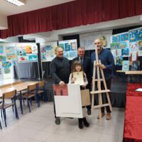 Na scenie na tablicach wyeksponowane są prace konkursowe, na scenie wójt i dyrektor szkoły i dwoje nauczycieli, którzy wręczają dzieciom nagrody