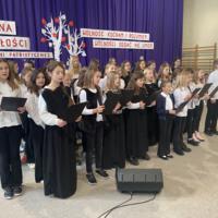 Sala gimnastyczna udekorowana fioletowymi zasłonami oraz napisami RADOSNA NIEPODLEGŁOŚCI gminny konkurs pieśni patriotycznych oraz Wolność kocham i rozumiem - wolności oddać nie umiem, zdjęcia występów konkursowych, wójta dyrektora szkoły, nauczycieli itp...