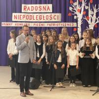 Sala gimnastyczna udekorowana fioletowymi zasłonami oraz napisami RADOSNA NIEPODLEGŁOŚCI gminny konkurs pieśni patriotycznych oraz Wolność kocham i rozumiem - wolności oddać nie umiem, zdjęcia występów konkursowych, wójta dyrektora szkoły, nauczycieli itp...