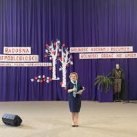 Sala gimnastyczna udekorowana fioletowymi zasłonami oraz napisami RADOSNA NIEPODLEGŁOŚCI gminny konkurs pieśni patriotycznych oraz Wolność kocham i rozumiem - wolności oddać nie umiem, zdjęcia występów konkursowych, wójta dyrektora szkoły, nauczycieli itp...