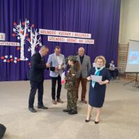 Sala gimnastyczna udekorowana fioletowymi zasłonami oraz napisami RADOSNA NIEPODLEGŁOŚCI gminny konkurs pieśni patriotycznych oraz Wolność kocham i rozumiem - wolności oddać nie umiem, zdjęcia występów konkursowych, wójta dyrektora szkoły, nauczycieli itp...
