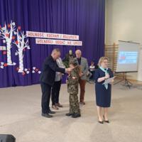 Sala gimnastyczna udekorowana fioletowymi zasłonami oraz napisami RADOSNA NIEPODLEGŁOŚCI gminny konkurs pieśni patriotycznych oraz Wolność kocham i rozumiem - wolności oddać nie umiem, zdjęcia występów konkursowych, wójta dyrektora szkoły, nauczycieli itp...