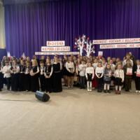 Sala gimnastyczna udekorowana fioletowymi zasłonami oraz napisami RADOSNA NIEPODLEGŁOŚCI gminny konkurs pieśni patriotycznych oraz Wolność kocham i rozumiem - wolności oddać nie umiem, zdjęcia występów konkursowych, wójta dyrektora szkoły, nauczycieli itp...