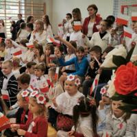 Obchody Narodowego Święta Niepodległości w Szkole Podstawowej w Marcinkowicach - dzieci na sali gimnastycznej wymachują biało-czerwonymi chorągiewkami