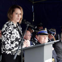 Uroczystość poświęcenia nowego samochodu strażackiego w OSP Paszyn.
Kobieta przemawia do mikrofonu.