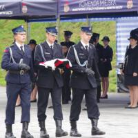 Uroczystość poświęcenia nowego samochodu strażackiego w OSP Paszyn.
Strażacy na placu w tle orkiestra strażacka