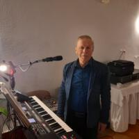 Bal seniora - przy stołach na których znajduje się poczęstunek i napoje siedzą seniorzy - sala jest elegancko przystrojona, niektórzy tańczą