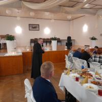 Bal seniora - przy stołach na których znajduje się poczęstunek i napoje siedzą seniorzy - sala jest elegancko przystrojona, niektórzy tańczą