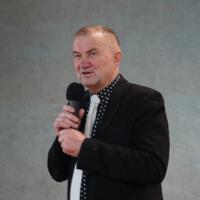 Wójt gminy trzyma w rękach mikrofon