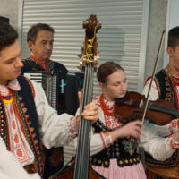4 osoby w strojach regionalnych z instrumentami muzycznymi