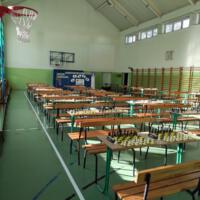 Sala gimnastyczna z przygotowanymi stolikami i zestawami do gry w szachy