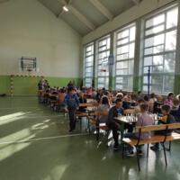 Zawodnicy grają w szachy na sali gimnastycznej