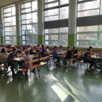 Zawodnicy grają w szachy na sali gimnastycznej