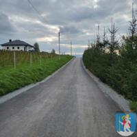 Droga asfaltowa - po obu stronach zielone łąki.