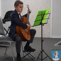 Młody chłopak elegancko ubrany gra na gitarze