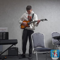 Młody chłopak gra na gitarze elektrycznej