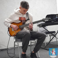Młody chłopak gra na gitarze elektrycznej