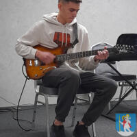 Młody chłopak gra na gitarze elektrycznej