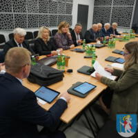 Sesja Rady Gminy Chełmiec - radni siedzą przy stole na sali posiedzeń