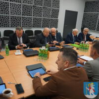 Sesja Rady Gminy Chełmiec - radni siedzą przy stole na sali posiedzeń