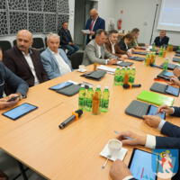 Sesja Rady Gminy Chełmiec - radni siedzą przy stole na sali posiedzeń